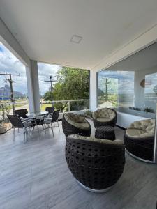 a living room with a tub and a table and chairs at Hotel Dois Montes in Itamaraju