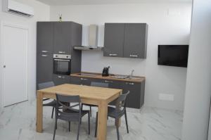 una cucina con un tavolo di legno e alcune sedie di La perla di Giada 1 a Bisceglie