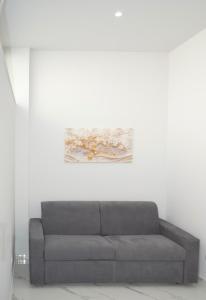 un divano in una stanza con un dipinto sul muro di La perla di Giada 1 a Bisceglie