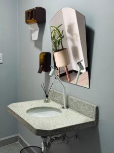 a bathroom counter with a sink and a mirror at Hotel Dois Montes in Itamaraju +56 photos