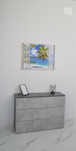 un comò in una stanza con una foto sul muro di La perla di Giada 1 a Bisceglie