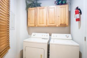 eine Waschküche mit zwei weißen Waschtischen und Holzschränken in der Unterkunft Sonoran Sea in Campo del Medio