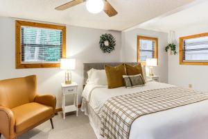a bedroom with a bed and a chair at Cartecay River Retreat with Yard and Screened Porch! in Ellijay