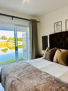 a bedroom with a bed and a large window at BKM Lake View Retreat at Leisure Bay Estate in Pretoria