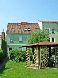 um gazebo num quintal em frente a um edifício em Ferienwohnung Am Ueckerpark em Ueckermünde