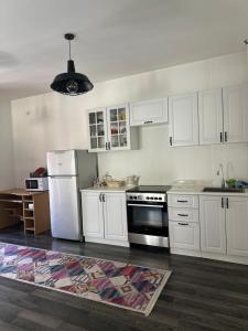 a kitchen with white cabinets and a white refrigerator at Half & Half Apartments in Pristina