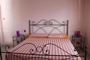 a bed with a metal frame and two night stands at Green Blue Beach House in Baie Lazare Mahé