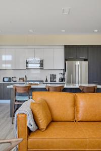 a living room with a brown couch in a kitchen at Lofted Living | Espadin LoHi in Denver +29 photos