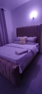 a large bed in a room with purple lighting at Luvuno accommodation in Mombasa