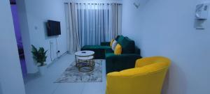 a living room with a green couch and yellow chairs at Luvuno accommodation in Mombasa