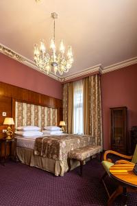 a bedroom with a bed and a chandelier at Heritage Boutique Hotel Sighisoara in Sighişoara +126 photos