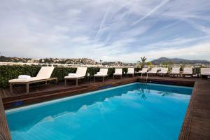 a swimming pool with lounge chairs and a resort at Splendid Hotel & Spa Nice in Nice