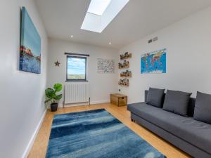 a living room with a couch and a blue rug at Tregarden in Poundstock +19 photos
