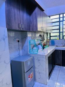 a kitchen with a sink and a refrigerator at Jordan House in Voi