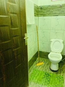 a bathroom with a toilet and a mop on the floor at Jordan House in Voi +13 photos