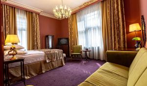 a hotel room with a bed and a chandelier at Heritage Boutique Hotel Sighisoara in Sighişoara