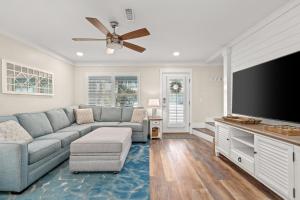 a living room with a couch and a flat screen tv at 140 Feet To White Sandy Beaches! Newly Renovated! Pool! Grill! in Laguna Beach