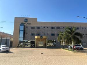 a building with a car dealership in a parking lot at Felipe Hotel in Serra Talhada