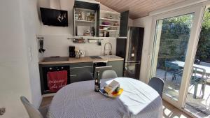 a kitchen and dining room with a table and a sink at Les Pâquerettes in Dinan