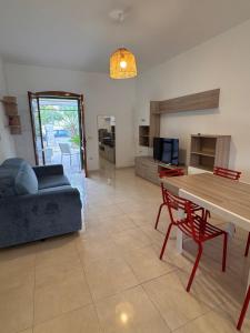 a living room with a table and a couch at Casa delle Mimose Baia Verde in Baia Verde +11 photos