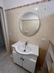 a bathroom with a sink and a mirror at Casa delle Mimose Baia Verde in Baia Verde