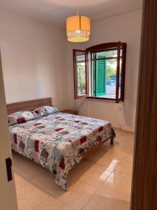a bedroom with a bed and a window at Casa delle Mimose Baia Verde in Baia Verde