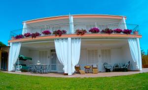 a round house with a balcony with flowers on it at Villa Regina B&B in Nettuno