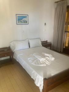 a bed with white sheets and towels on it at Liberty-Room N2 in Georgioupolis