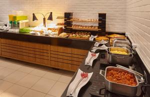 Una línea de buffet en un restaurante con comida. en Hotel Nacional Inn Bauru, en Bauru