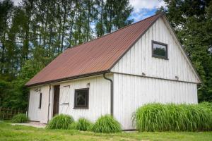 a white barn with a red roof at Wigierska Piertówka 2 in Suwałki