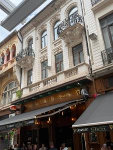 ブカレストにあるRoyality Bucharest Old Townの目の前に人が立つ建物