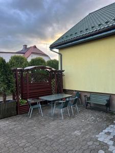 un patio con tavolo, sedie e panca di Zacisze Augustów Apartament nr 3 a Skorka