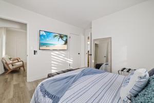 Un dormitorio con una cama y un televisor en la pared. en La Casita St Pete, en San Petersburgo