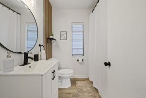 a bathroom with a sink and a toilet and a mirror at La Casita St Pete in St. Petersburg +16 photos