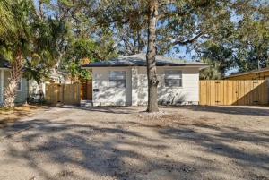 una pequeña casa blanca con un árbol en la entrada en La Casita St Pete, en San Petersburgo