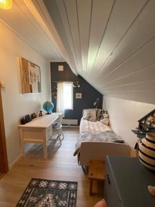 a bedroom with a bed and a desk in a room at Downtown and rural, walking distance to city center in Sauda