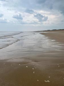 una playa vacía con huellas en la arena en Our Happy Place, en Anderby