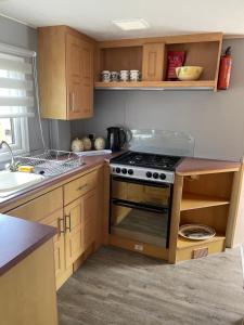 una cocina con estufa y encimera en Our Happy Place, en Anderby