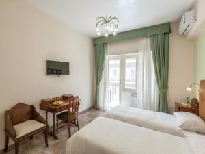 ローマにあるAnice Affittacamereのベッド2台、デスク、窓が備わるホテルルームです。