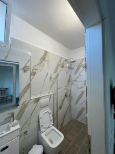 a bathroom with a toilet and a sink at Villa Besnik in Sarandë