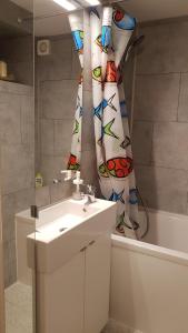 a bathroom with a sink and a shower curtain at Type 2 hypercentre 100 m de la mer in Cabourg +23 photos