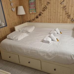 a white bed with towels and pillows on it at Type 2 hypercentre 100 m de la mer in Cabourg