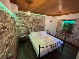 a bedroom with a bed in a brick wall at Guest House Bala in Gjirokastër