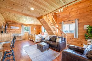 a living room with a couch and a staircase at Cloud 9 Cabin with an indoor pool hot tub & fire pit in Bryant