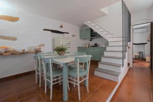 a kitchen with a table and chairs and a staircase at La casa dei mestieri in Lanusei