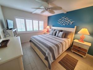 a bedroom with a bed and a ceiling fan at Summerhouse 104 in Saint Augustine +26 photos