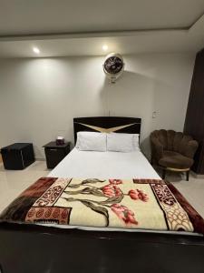 a bedroom with a bed and a chair at Rent Buddy in Islamabad