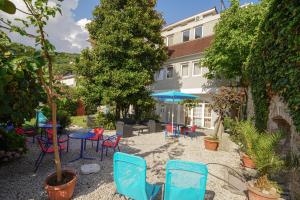 un patio avec des chaises et des tables et un bâtiment dans l'établissement LaRos Apt, à Herceg-Novi