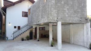 a large concrete building with a staircase on it at Chalés Recanto das Rosas in Monte Verde