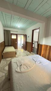 a hotel room with two beds with towels on them at Chalés Recanto das Rosas in Monte Verde